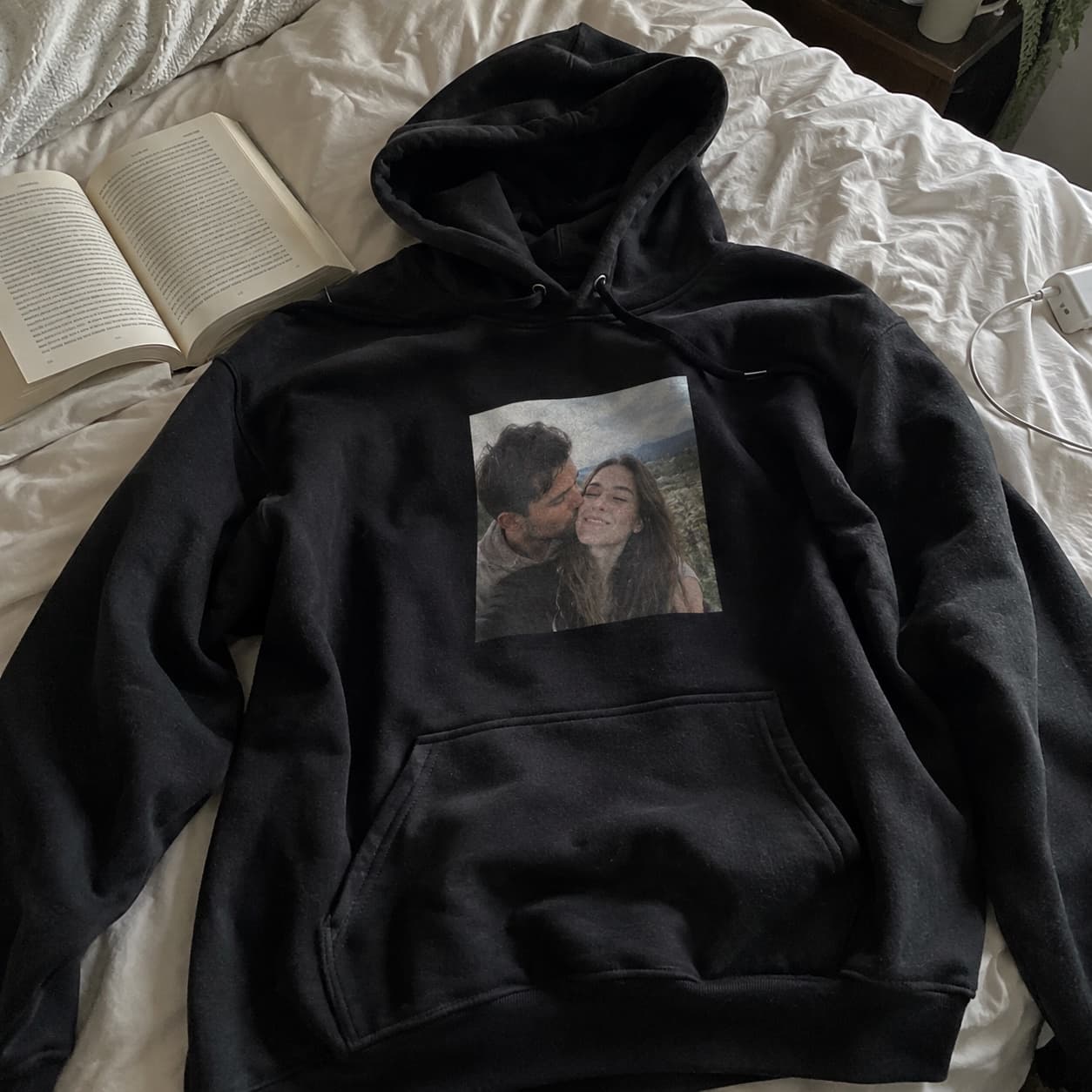Foto-Hoodie auf einem ungemachten Bett