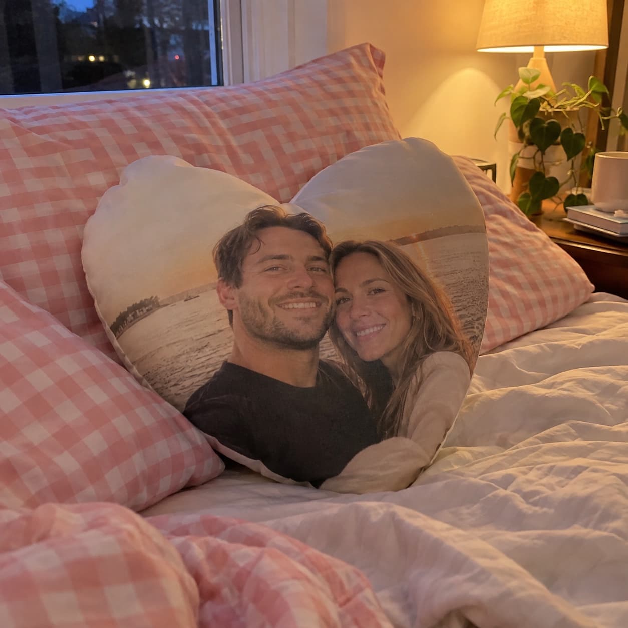 Herzförmiges Fotokissen auf einem Bett
